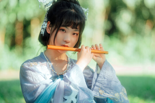 Asian teenage girl playing bamboo flute