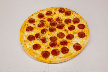 Family-size pizza with lots of pepperoni slices and lots of gratin cheese