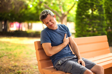 Obraz premium Man with heart pain outdoor. Healthcare and medicine concept
