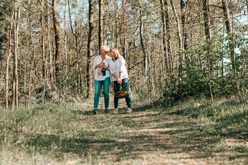 Fototapeta premium Two female friends mature are walking through forest. Active lifestyle, hobby