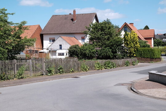 Leere Stra&szlig;e im Sommer bei Sonnenschein in einem Wohngebiet in der Provinz in Alverdissen im Exertal bei Barntrup im Kreis Lippe in Ostwestfalen-Lippe