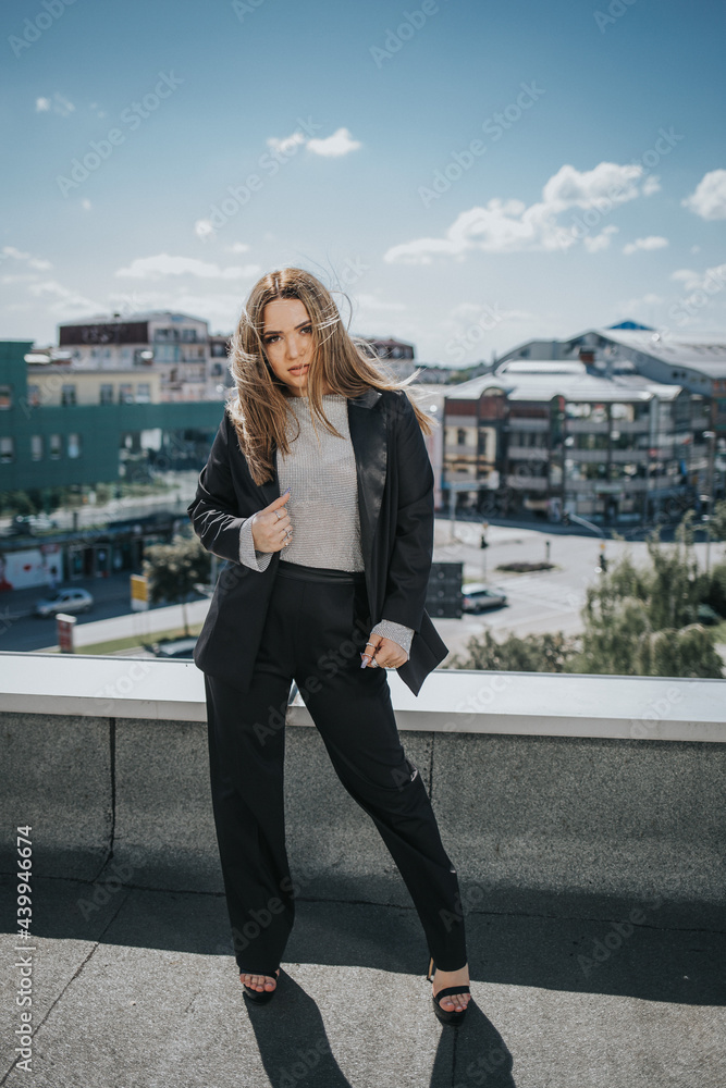 Poster Pretty Caucasian lady wearing a blazer and posing on a bridge