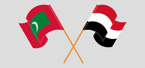 Crossed and waving flags of Maldives and Yemen