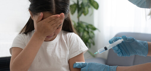 nurse giving vaccination injection to little girl patient