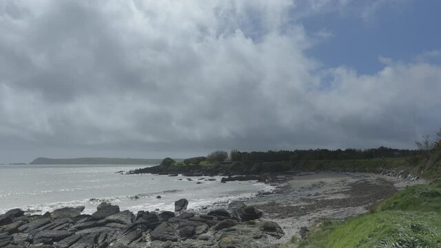 idyllic beach on the Cooper Coast, Ireland. cove near Dungarvan. Strong waves and stormy cloud . Waterford country