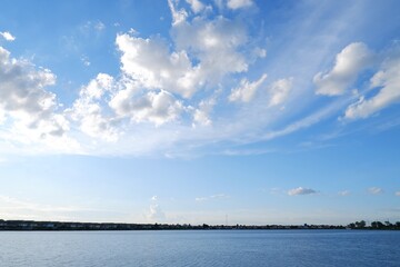 Fototapeta na wymiar blue sky with white clouds on river on natural light background