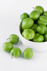 fresh and green plum on white background