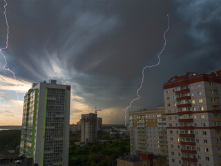 Several lightning bolts in one shot against the background of the city district of high-rise...