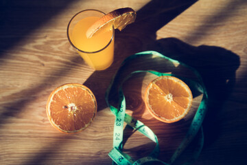 orange on the table, measuring tape and orange juice © Fantastic