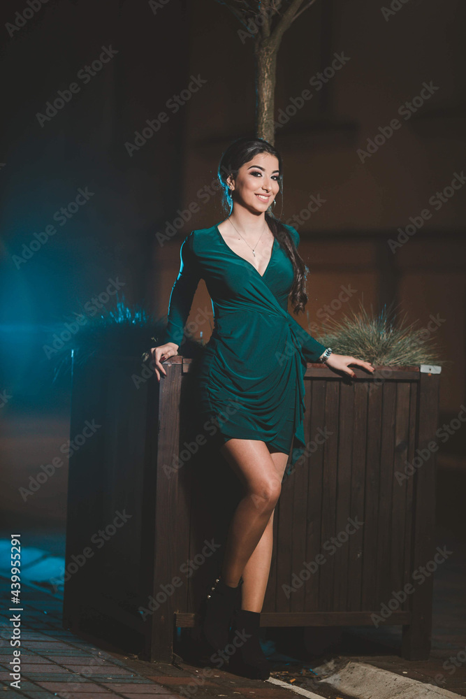 Poster young female from bosnia and herzegovina in a green elegant dress leaning on a big wooden pot