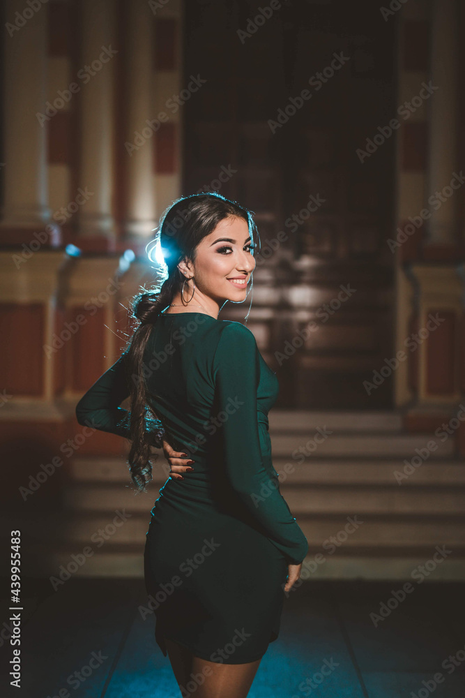 Sticker young female from bosnia and herzegovina in a green elegant dress posing in the park at night