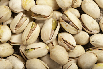 Pistachio nuts arranged on a burlap cloth. A tasty snack consumed with beer.