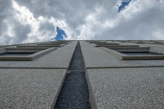 Grey Precast Concrete Exterior Cladding Panels On A Multi-storey Building, Sky And Clouds Above, Nobody