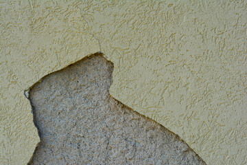 Plaster/stucco is cracking and peeling away from exterior of commercial building.