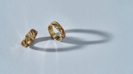 Pair of elegant shiny golden rings with carvings