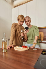 Homosexual male pair looking into smartphone screen