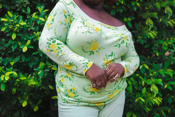 woman against a bed of green leaves with matching green outfit.
