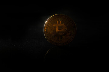 TABLE BACKED BITCOIN COINS ON BLACK BACKGROUND