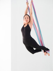 Young beautiful Asian dancer dressed in black color performing aerial dance with multi-color...