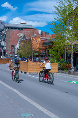 Banff village street with bikers riding down town COVID-19 sign