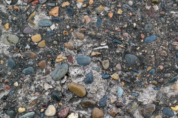 Concrete surface with inclusions of colored stones.