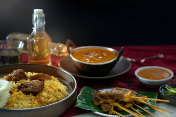 Traditional Muslim food on table, beef Biryani, yellow rice cooked with aromatic spices with beef, curry, Beef satay, selective focus
