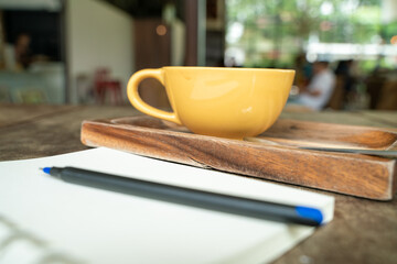 Notebook text with coffe cup on wooden table