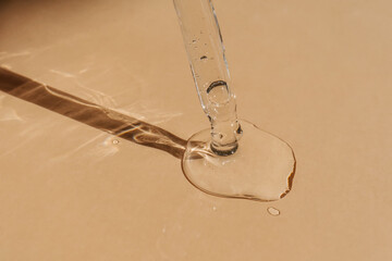 A drop of cosmetic oil falls from the pipette