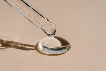 A drop of cosmetic oil falls from the pipette