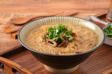 Delicious intestine vermicelli in a bowl on dark wooden table background.