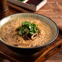 Delicious intestine vermicelli in a bowl on dark wooden table background.