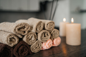 SPA-center. Towels, aromatic oil and candles in the massage parlor. Close-up