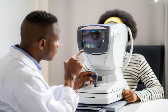 Optician Doing Optometry Eye Exam of black african american teen girl in modern clinic. Doctor and patient in ophthalmology clinic.