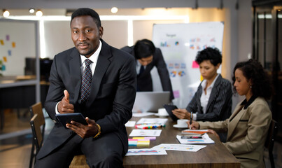 African black executive successful male business owner sitting at desk in indoor office with...