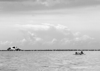 Fototapeta premium Dramatic image of a shipwreck of an abandoned boat off the Caribbean coast with crystal clear water and cloudy skies, in Boca Chica, Dominican Republic.