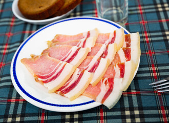 Appetizing jucy slices of fresh sliced bacon on a platter