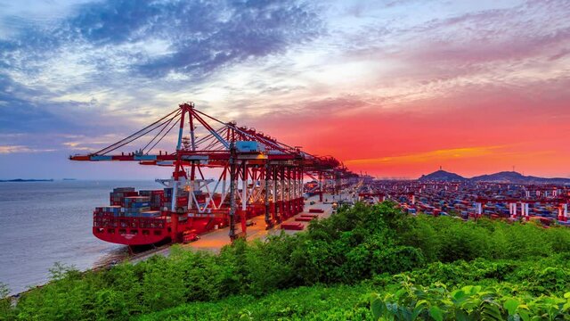 Container ship loading and unloading in deep sea port,business logistic import and export freight transportation by container ship.Busy container port at sunset.industrial scene,4k time lapse.