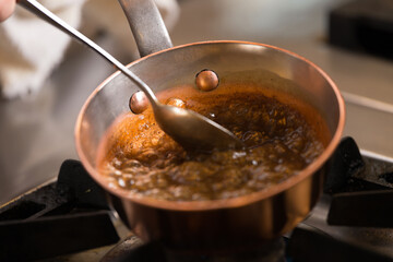 Chef making caramel in a pan on the fire - obrazy, fototapety, plakaty