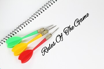arrows, white paper with the words rules of the game