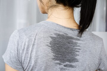 closeup Asian woman sweating because of hot weather , wet on her back