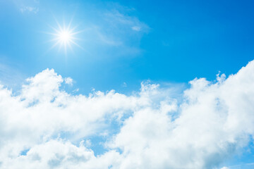 Naklejka na ściany i meble Sun with sunlight in white clouds on blue sky.