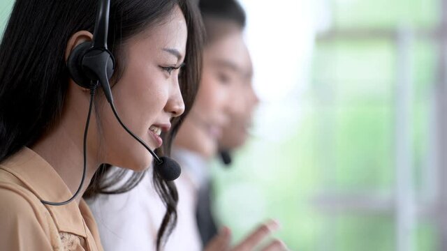 woman and man team call center working on station of computer. Smiling staff for customer support. People talking on headphone microphone in feeling happy.