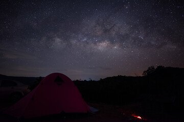 milky way galaxy and space dust in the universe, Night starry sky with stars. with tent tourists in mountains at night. Long exposure photograph, with grain.