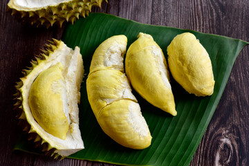 Durian fruit. Ripe durian. Tasty durian that has been peeled on Banana leaves and old wood background, king of fruit from Thailand on summer season