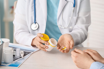 Female doctor giving medicine to patient in clinic, closeup