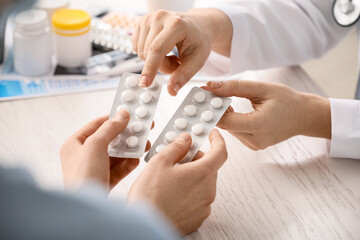 Female doctor giving medicine to patient in clinic, closeup