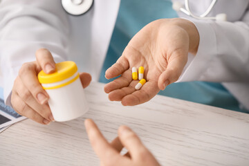 Female doctor giving medicine to patient in clinic, closeup