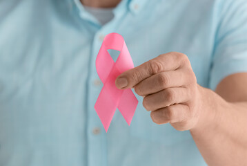 Man with pink ribbon, closeup. Breast cancer awareness concept
