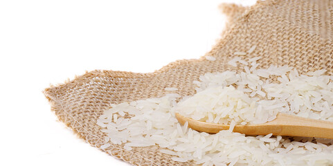 raw and uncooked rice in wooden spoon on hemp sackcloth