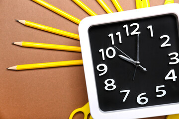 Composition with stylish clock and stationery on color background, closeup